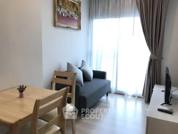 Cozy living room with natural light and modern furnishings in a stylish apartment.