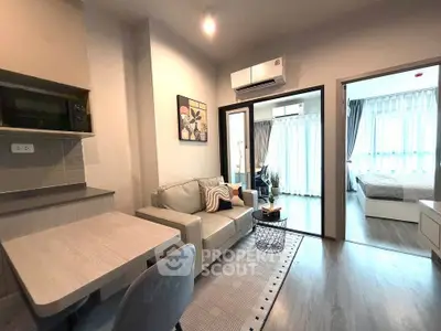 Modern living room with cozy sofa and stylish decor adjacent to a bright bedroom.