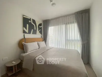 Cozy bedroom with modern art and large window in stylish apartment