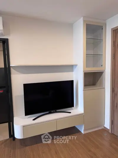 Modern living room with sleek TV unit and wooden flooring, perfect for stylish urban living.