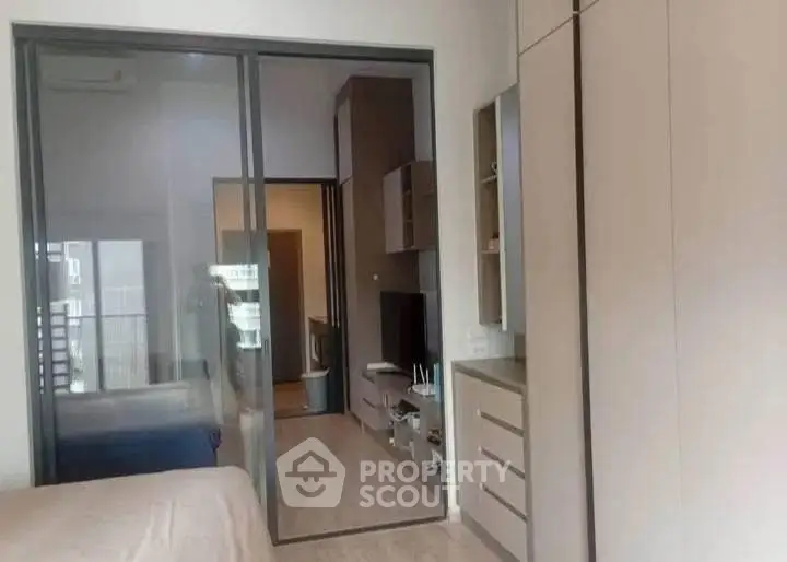 Modern bedroom with sliding glass doors and built-in storage solutions