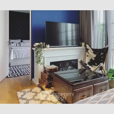 Stylish modern living room with fireplace and TV, adjacent to elegant bedroom.