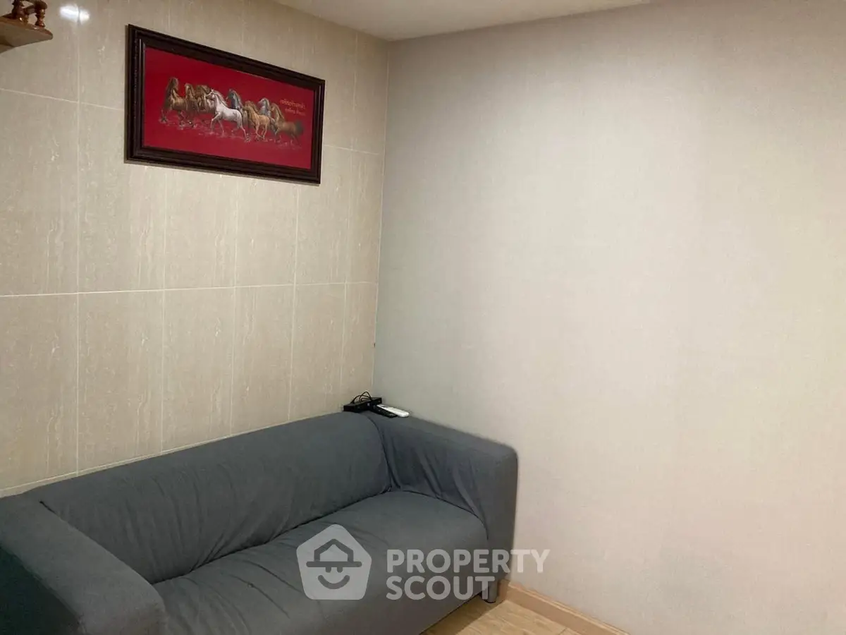 Cozy living room with modern gray sofa and elegant wall art, perfect for relaxation.