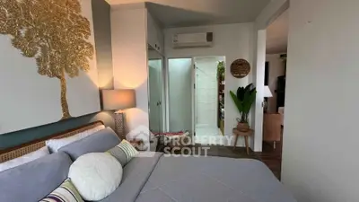 Cozy bedroom with modern decor and air conditioning, featuring a stylish lamp and wall art.