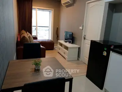 Modern living room with cozy seating and sleek TV setup in a stylish apartment.