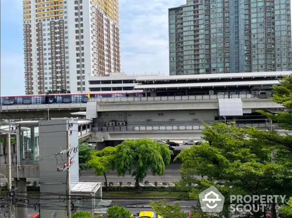 Urban high-rise buildings near public transit station with lush greenery