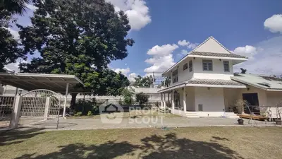 Charming two-story house with spacious garden and carport, perfect for family living.