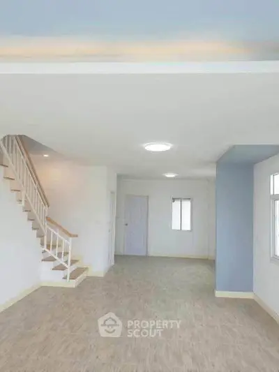Spacious open-plan living area with staircase and natural light
