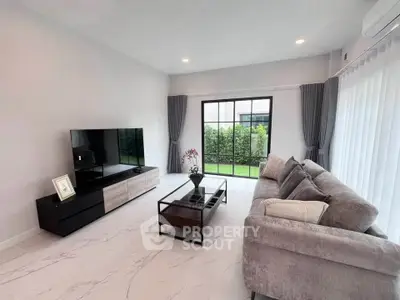 Spacious modern living room with large windows and elegant decor, perfect for relaxation and entertainment.