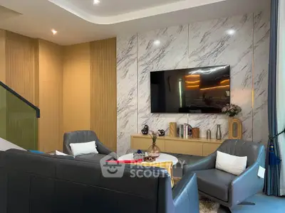 Modern living room with marble accent wall and sleek furniture