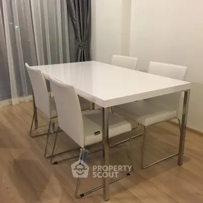 Modern dining area with sleek white table and chairs, perfect for contemporary living spaces.
