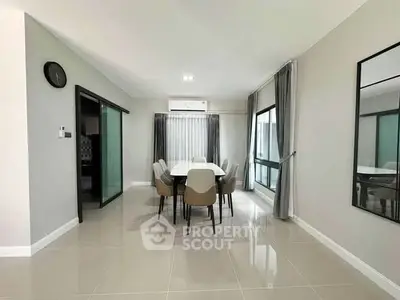 Modern dining area with sleek design and large windows for natural light.