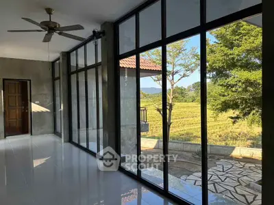 Spacious room with floor-to-ceiling windows offering stunning countryside views.
