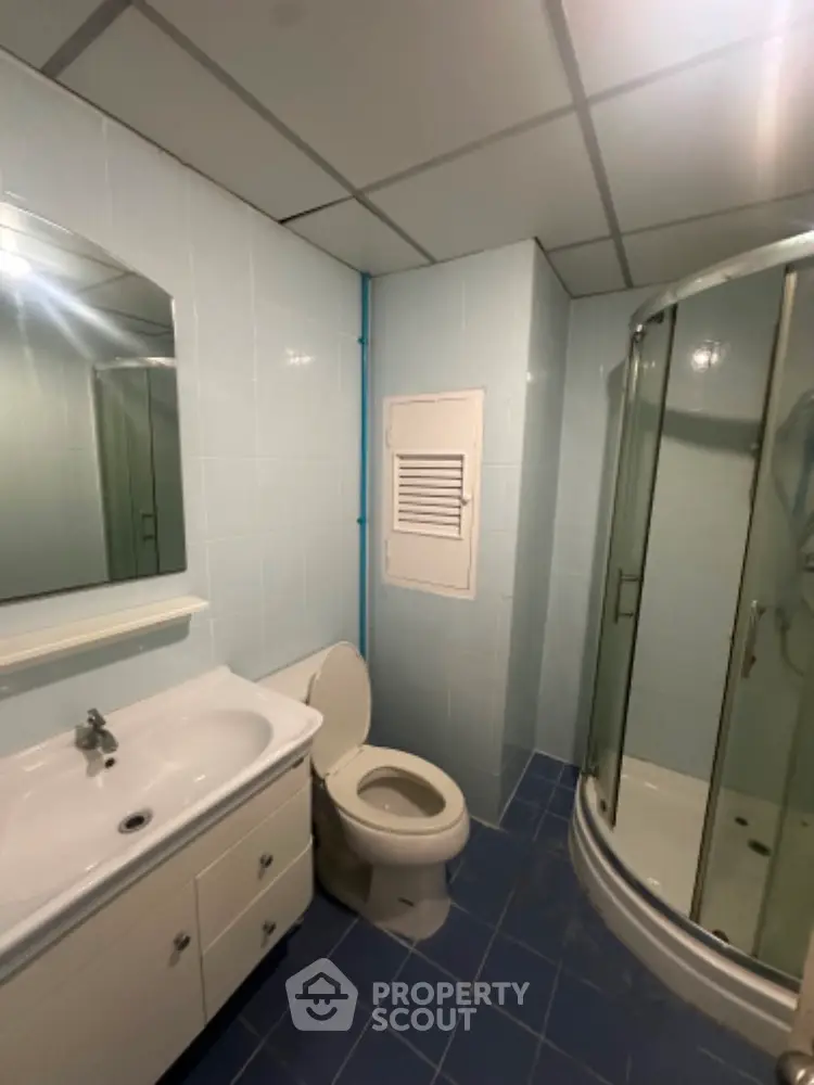 Modern bathroom with shower cabin and sleek vanity in a contemporary home.