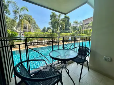 Charming balcony with pool view, perfect for relaxation and outdoor dining in a serene setting.