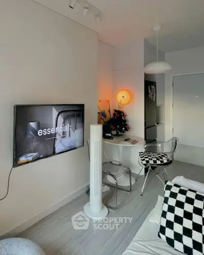 Modern living room with sleek decor and wall-mounted TV in a stylish apartment.