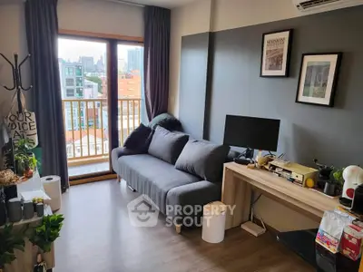 Modern living room with balcony view in urban apartment, featuring sleek furniture and stylish decor.