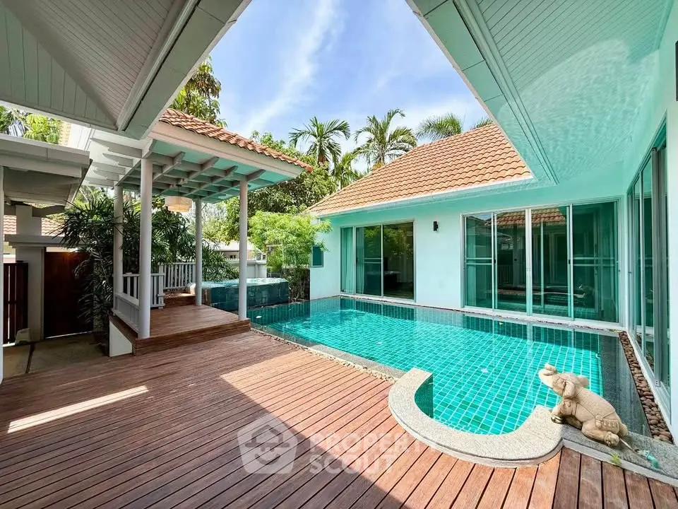 Luxurious villa with private pool and wooden deck, surrounded by lush greenery and modern architecture.