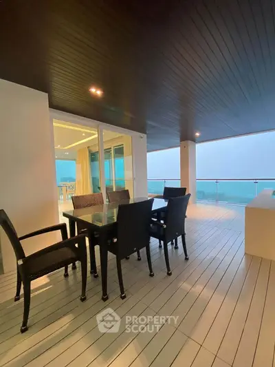 Luxurious balcony with ocean view and modern outdoor dining set, perfect for relaxation and entertainment.