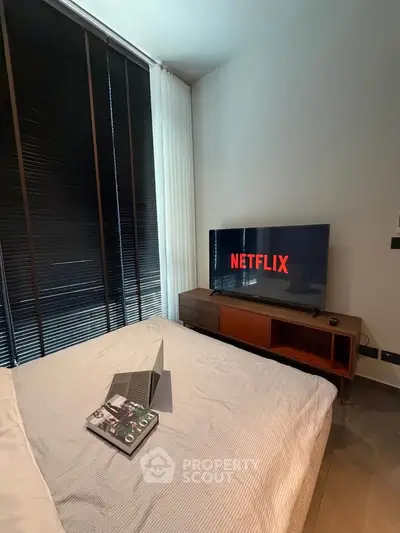 Modern bedroom with sleek TV setup and cozy ambiance, perfect for relaxation and entertainment.