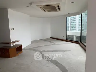 Spacious unfurnished living room with large windows and city view