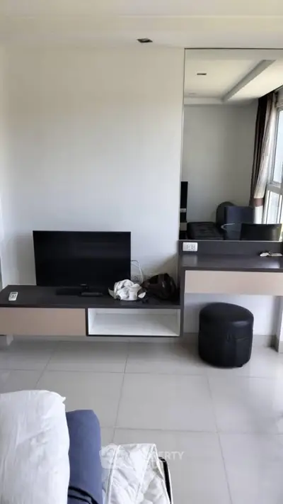 Modern bedroom with sleek TV setup and stylish vanity area