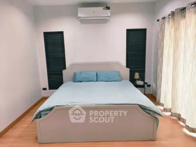 Modern bedroom with stylish decor and air conditioning, featuring a comfortable bed and elegant curtains.