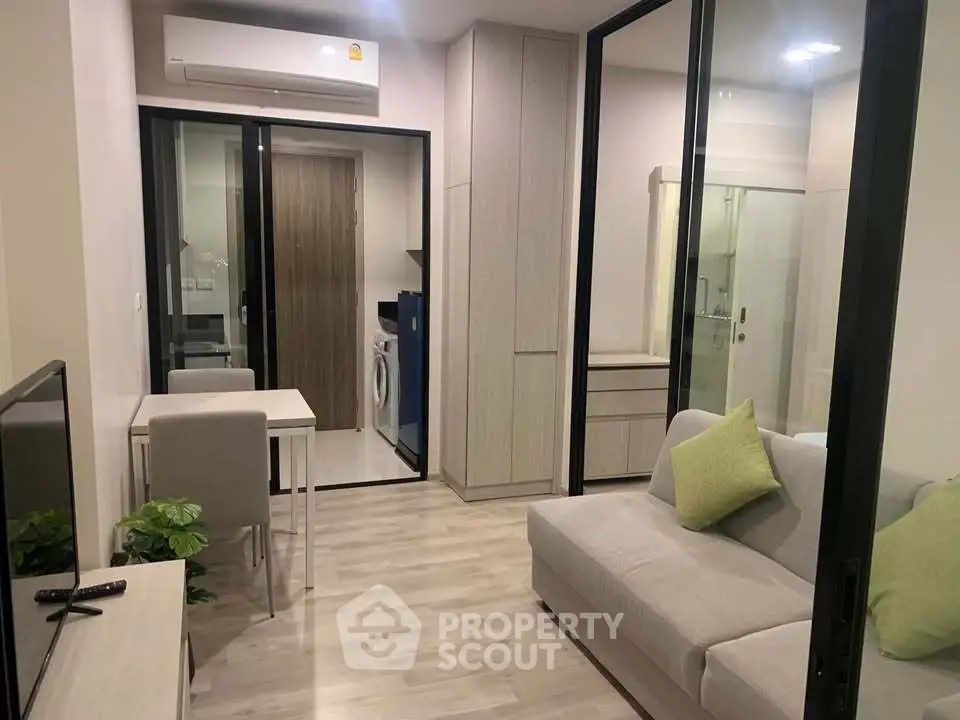 Modern living room with sleek design and open layout, featuring a cozy sofa and dining area.