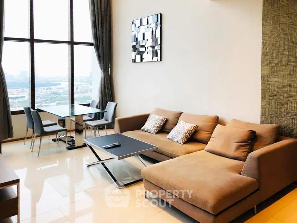 Spacious modern living room with large windows and city view, featuring a stylish sofa and dining area.