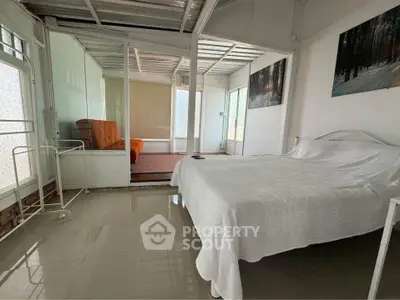 Spacious bedroom with modern decor and natural light in a cozy real estate property.