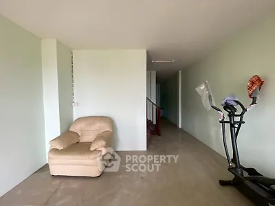 Spacious interior with exercise equipment and cozy seating area, ideal for home gym setup.