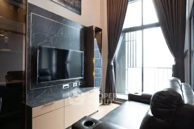 Luxurious living room with modern TV setup and floor-to-ceiling windows opening to a balcony.