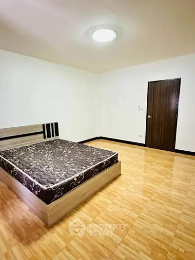 Spacious bedroom with modern bed and tiled flooring in minimalist design.