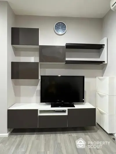 Modern living room with sleek TV unit and wall shelves, perfect for stylish home entertainment setup.