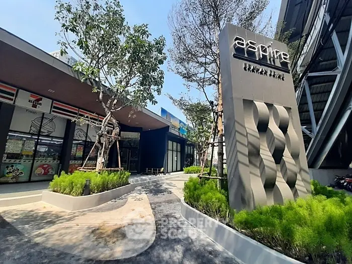 Modern commercial building exterior with landscaped entrance and signage.