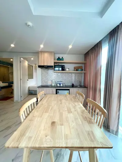 Modern kitchen with wooden dining table and open shelving in bright apartment