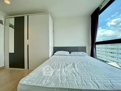 Bright bedroom with large window offering stunning city view and modern wardrobe.