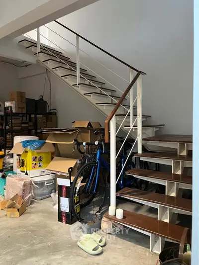 Spacious storage area with modern staircase and bicycle, ideal for organizing and maximizing space.