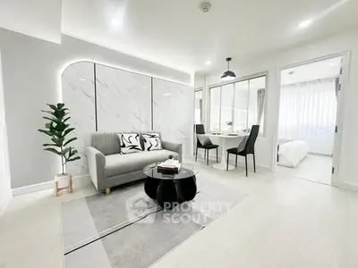 Modern living room with stylish decor and open layout leading to bedroom