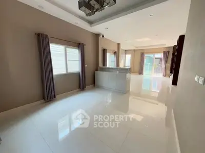 Spacious modern living room with large windows and elegant lighting.