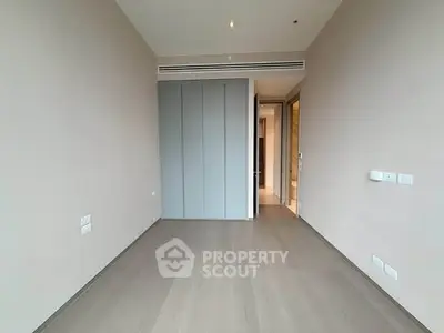 Spacious empty room with modern design and wooden flooring, ideal for customization.