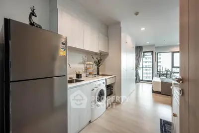 Modern kitchen with sleek appliances and open layout leading to a bright living area.