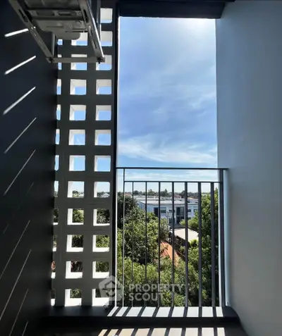 Charming balcony with modern lattice design and scenic view of lush greenery.