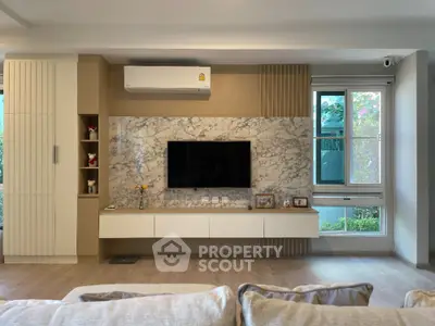 Modern living room with stylish TV wall and natural light
