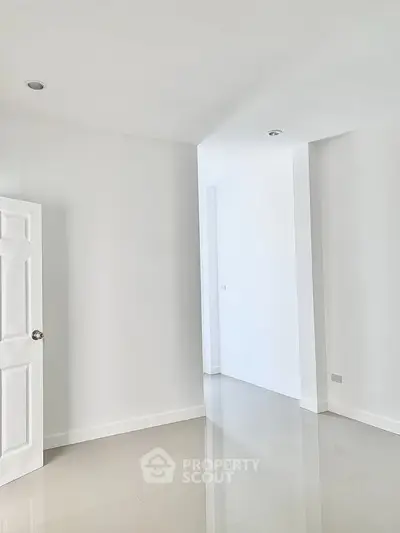 Spacious minimalist interior with glossy floors and white walls, perfect for customization.