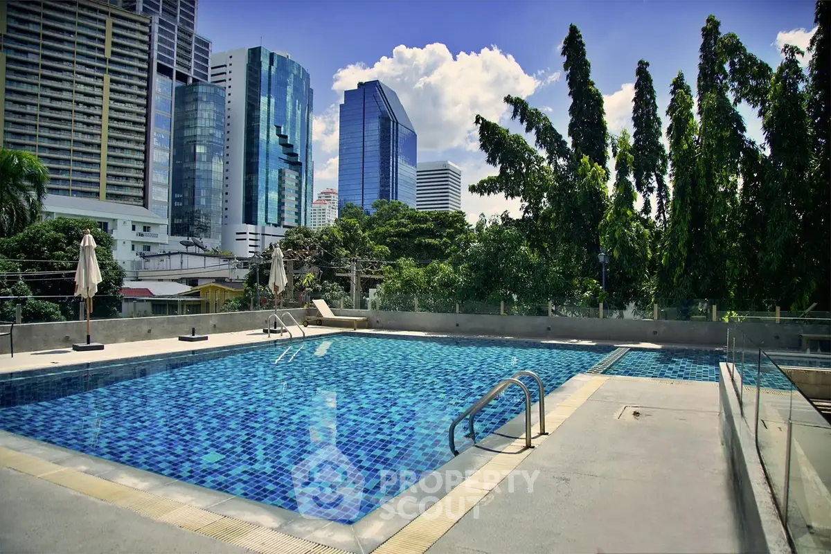 Luxurious rooftop pool with stunning city skyline views and lush greenery