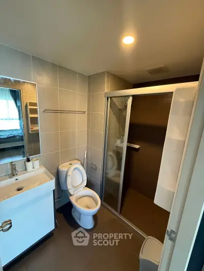 Modern bathroom with sleek shower and contemporary fixtures in a stylish apartment.