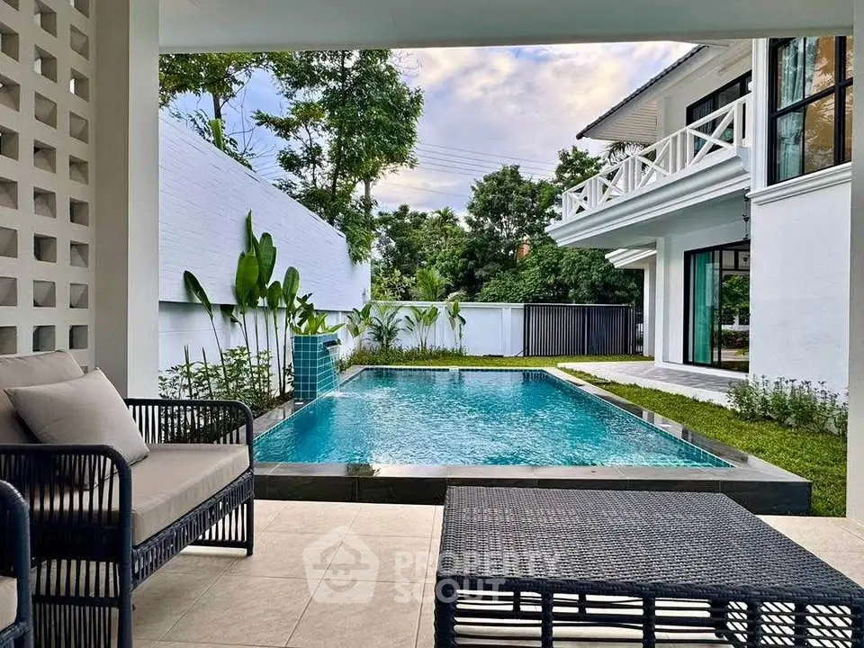 Luxurious modern home with private pool and spacious outdoor seating area, perfect for relaxation and entertainment.