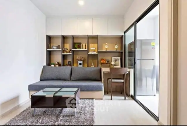 Modern living room with sleek furniture and open kitchen layout in a stylish apartment.