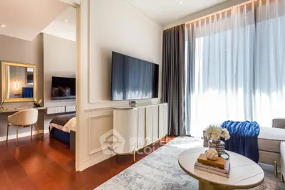 Luxurious modern living room with elegant decor and large TV, adjacent to a stylish bedroom.